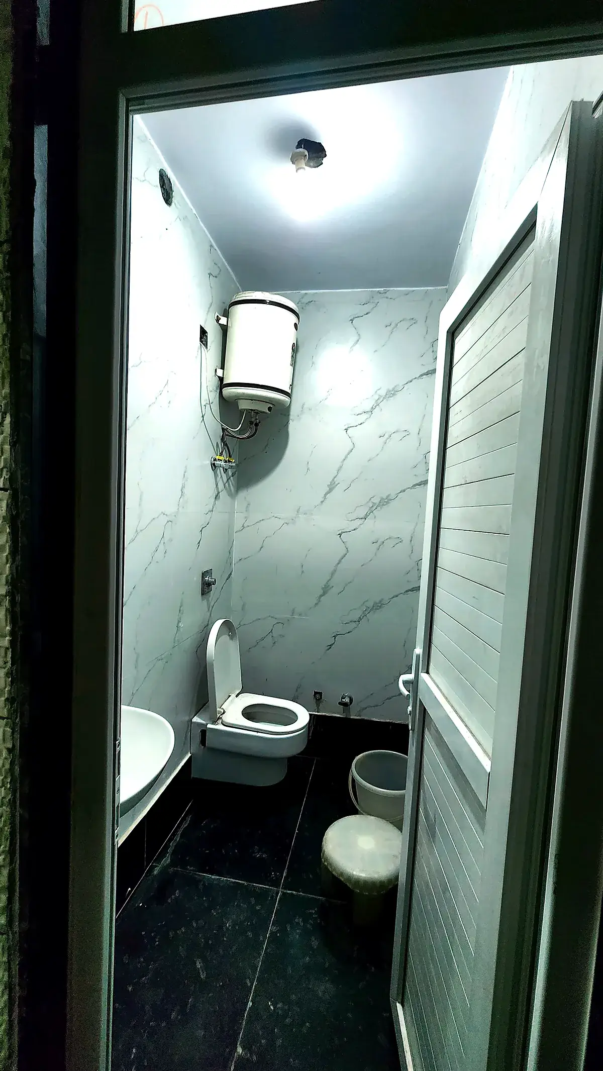 Freshly tiled washroom with geyser at PG for Girls in Rohini